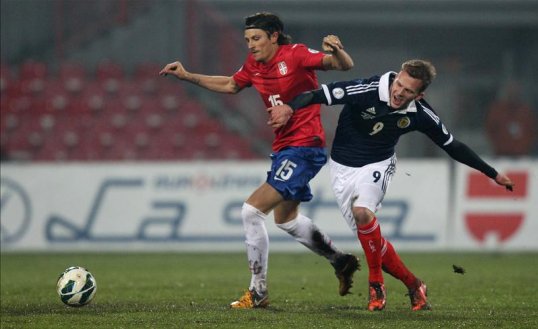 Two goals in five minutes from Filip Djuricic helped Serbia to an easy 2-0 win over a sluggish Scotland.