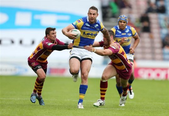 Huddersfield Giants beat Leeds Rhinos to keep the pressure on the Wigan Warriors at the top of the Rugby League Super League.
